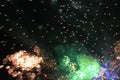 Fireworks. Firework. Heavenly background. Colorful wave of bright shimmering orange and green sparkling lights in the night sky