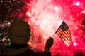 Fireworks at night. Woman in winter clothes with American flag.