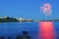 Fireworks shining above city center and reflecting on sea water at blue hour Royalty Free Stock Photo