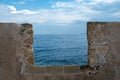 Firkas Fortress worn wall at Old Town of Chania Crete, Greece. View of sky, sea from castle opening