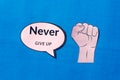 Firm human hand with motivation text on speech bubble isolated on blue background. Conceptual image shows believing in yourself Royalty Free Stock Photo