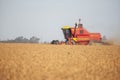 Red combine harvesting soybean