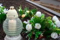 Firs november day.A candle and fake white roses at a cemetery