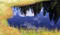 Firs reflection in the calm, blue water of a mountain lake Royalty Free Stock Photo