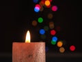 First Advent candle burns with Christmas lights bokeh Royalty Free Stock Photo