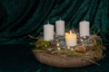 First Advent - self made Advent wreath with selective focus on foreground with one white candle burning, a tradition in the four Royalty Free Stock Photo