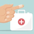 First aid kit and a finger with an adhesive bandage Royalty Free Stock Photo