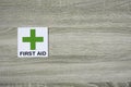 First aid sign on the wooden wall with space for adding text on the right side