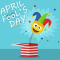 First April Fool Day happy holiday greeting card. Jack in the box toy on blue background. Jester hat and laughing