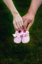 First baby girl shoes in a parent hands Royalty Free Stock Photo