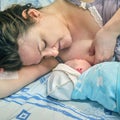 The first breast feeding of a newborn baby boy immediately after giving birth on a hospital bed in a maternity ward Royalty Free Stock Photo