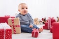 First Christmas: baby amongst red presents and is smiling Royalty Free Stock Photo