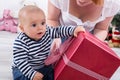 First Christmas: baby shaking big red gift box - cute little boy Royalty Free Stock Photo