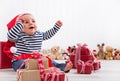 First Christmas: baby unwrapping a present - happy children eyes Royalty Free Stock Photo