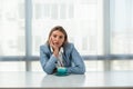 But first coffee. Young tired business woman in formal wear sitting in the office at empty desk with cup of coffee. Female white Royalty Free Stock Photo
