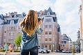 First day in new European city. Beutiful lady taking a photo of a house with digital camera. She is dressed in casual clothes. Vie