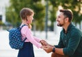 First day at school. father leads little child school girl in first grade