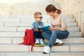 First day at school. mother and little schoolboy son sit on the stairs together Royalty Free Stock Photo