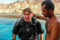 First dive in Red Sea near Aqaba resort in Jordan. Young scuba diver in equipment with instructor