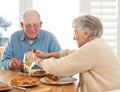 First we eat then do everything else. a senior couple eating their lunch together.