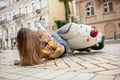 Woman laying on pawement after falling from a scooter.