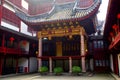 On the first floor of the ancient Chinese attic, there are red wooden columns, golden carvings, and red lanterns hanging under the