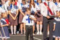 First-form schoolboy at school on holiday of beginning of elementary education reading poetry. Boy with microphone declaiming Royalty Free Stock Photo