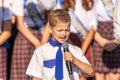 First-form schoolboy at school on holiday of beginning of elementary education reading poetry. Boy with microphone declaiming Royalty Free Stock Photo