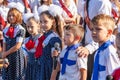 First-form schoolboy at school on holiday of beginning of elementary education reading poetry. Boy with microphone declaiming Royalty Free Stock Photo