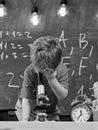 First former interested in studying, learning, education. Kid boy looks into microscope in classroom, chalkboard on