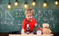 First former interested in studying, learning, education. Kid boy near microscope in classroom, chalkboard on background