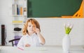 First grade. Kid studying at school. Schoolchild doing homework at classroom. Education for kids.