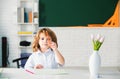 First grade. Kid studying at school. Schoolchild doing homework at classroom. Education for kids.