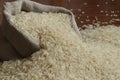 Rice grains are poured into a linen bag.