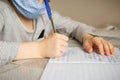 A first-grader boy in a mask is doing homework in quarantine because of a coronavirus Royalty Free Stock Photo