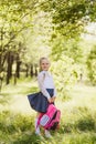 First-grader girl with a school pink backpack outdoors