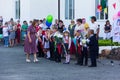 first-graders with bouquets of flowers and parents and teachers