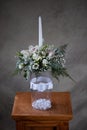 First holy communion flower bouquets. White candle decorated with orchid and flowers white flowers.