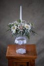 First holy communion flower bouquets. White candle decorated with orchid and flowers white flowers.