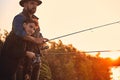 The first joint fishing of adult father and teen son in warm, sunny day. Royalty Free Stock Photo