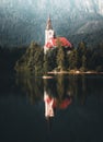 First light of sunrise on silhouette tower of Assumption of Mary church at Lake Bled