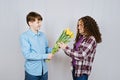 First love concept. Teen boy gives his girlfriend a bouquet of yellow tulips on white background. Royalty Free Stock Photo