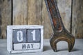 First May on calendar made wood and wrench on background.Concept Labor Day.