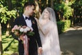 First meet of bride and groom on their wedding. Happy smile bride in veil touches the shoulder of groom in with bouquet