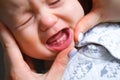 First milktooth and crying baby close up. Newborn tantrum child on mother hands. Family life, motherhood. Kids dentistry