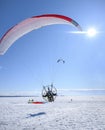The first moments of taking off a motor paraplane over a large snow covered lake in bright sunny weather
