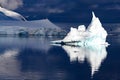 Iceberg shining in white, turquoise color at first morning sunlight in dark blue riffled Southern Antarctic Ocean, Antarctica