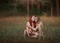 First people like Adam and Eve. Beautiful man and woman with long red hair with a rabbit sitting in a clearing. near the Royalty Free Stock Photo