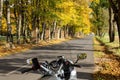 A first-person motorcycle journey. Autumn road leaves are yellow, green and orange. Selective focus. Moto dashboard.