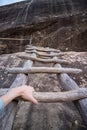 First person photo from a hiker climbing a wooden ladder up a cliff.